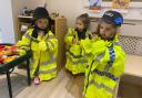 Children at Poppies Day Nursery have fun trying on police uniforms