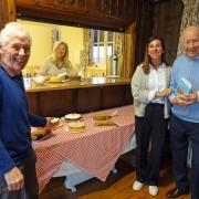 Barry Wienholdt, right, co-author of the original publication and creator of the new book enjoys tea and cakes with volunteers