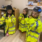 Children at Poppies Day Nursery have fun trying on police uniforms