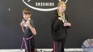 Thomas Cran-Crombie and Lyla Souch with their medals at the Academy of Martial Arts Cheshire
