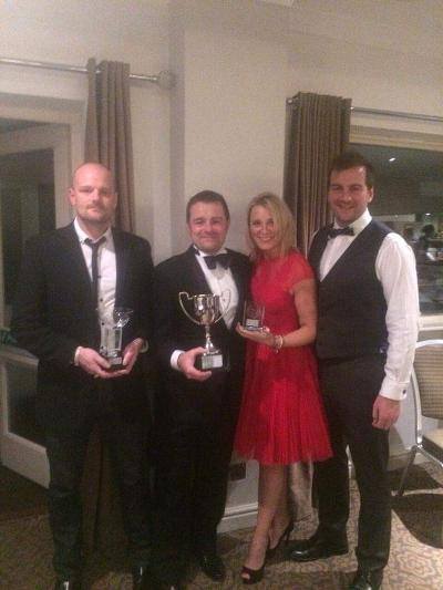 Eddie, holding one of the trophies, with wife, Emma and brothers Charlie (left) and Andrew (right)