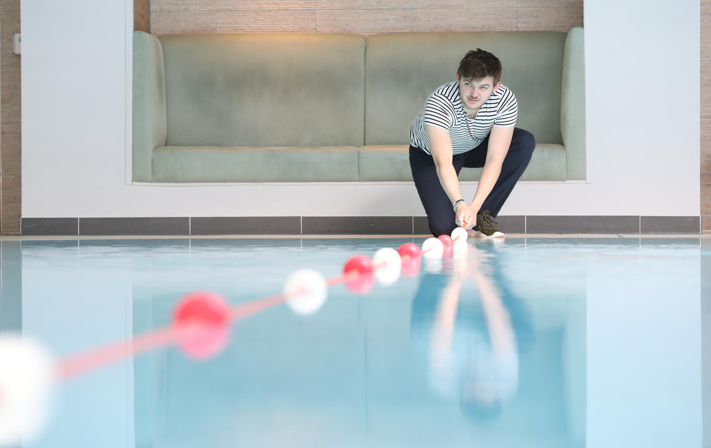 Spa assistant Kieran Wilson prepares the pool for socially distanced swimming at Cottons Hotel and Spa - PA Images