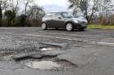 A car passes potholes in a road near Peterborough as Transport Secretary Mark Harper defended the Government’s record (Joe Giddens/PA)