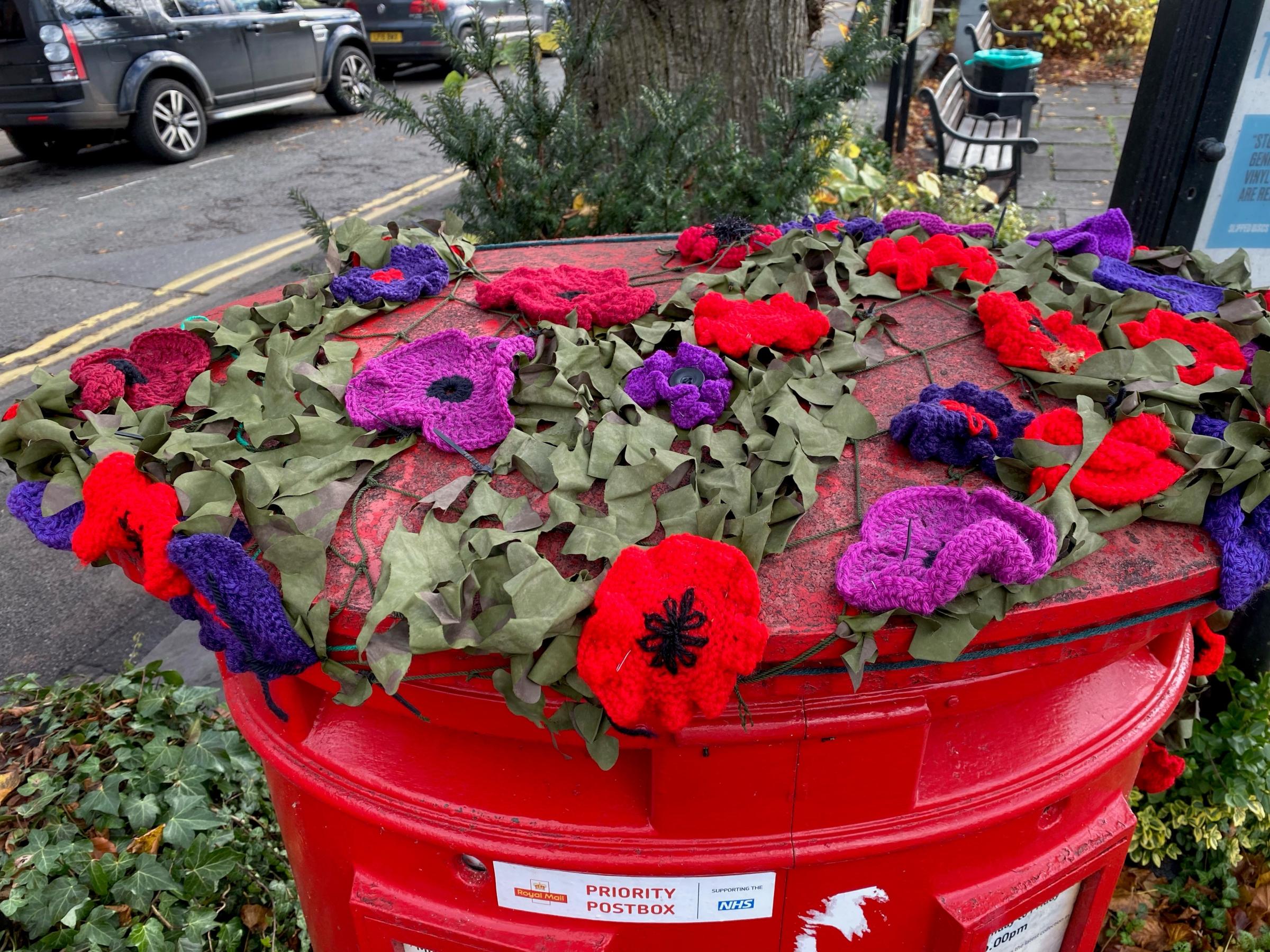 Some poppies have been placed on top of a postbox