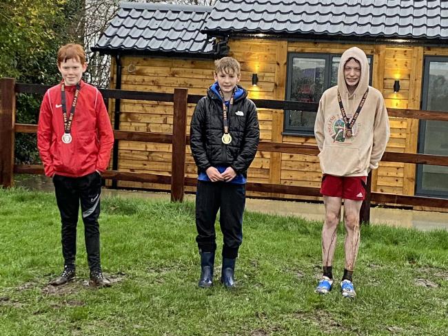 Ben Keeley, centre, with his 2022 Cheshire Cross Country Championships winner’s medal in Pickmere on Saturday. He is proving to be a consistent performer as he also won the under 11s title two years ago.