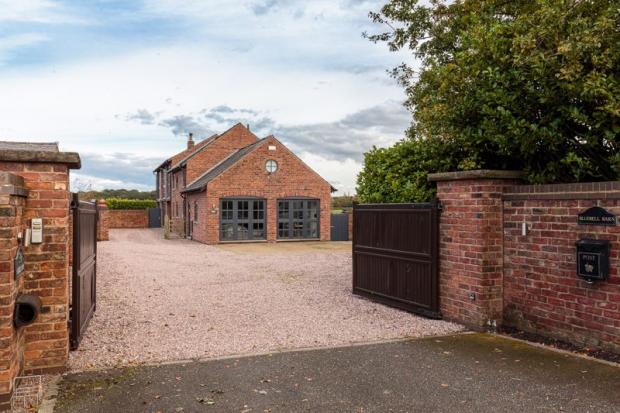 Knutsford Guardian: Electric gates lead into this bespoke barn conversion