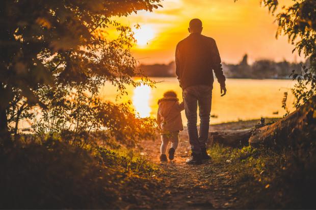 Knutsford Guardian: Father and child walking together at sunset. Credit: Canva