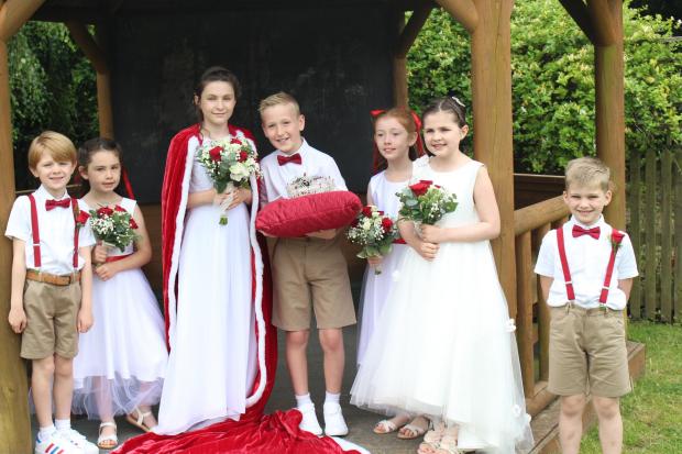Rose Queen Mollie Edwards Barnard and her retinue Macy Edwards Barnard (chief attendant), Percy Bratherton (crown bearer), Scarlett Brooker and Abigail Walter (small attendants) and Arlo Mitchell and Brodi Wilcox (train bearers)