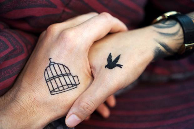 Knutsford Guardian: Two people with tattoos holding hands (Canva)