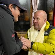 Steve Buckley,  right, receives traditional silk scarves from Devendra, one of the trekking guides