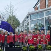 Children from Goostrey Community Primary School crown T-Rex to celebrate the coronation